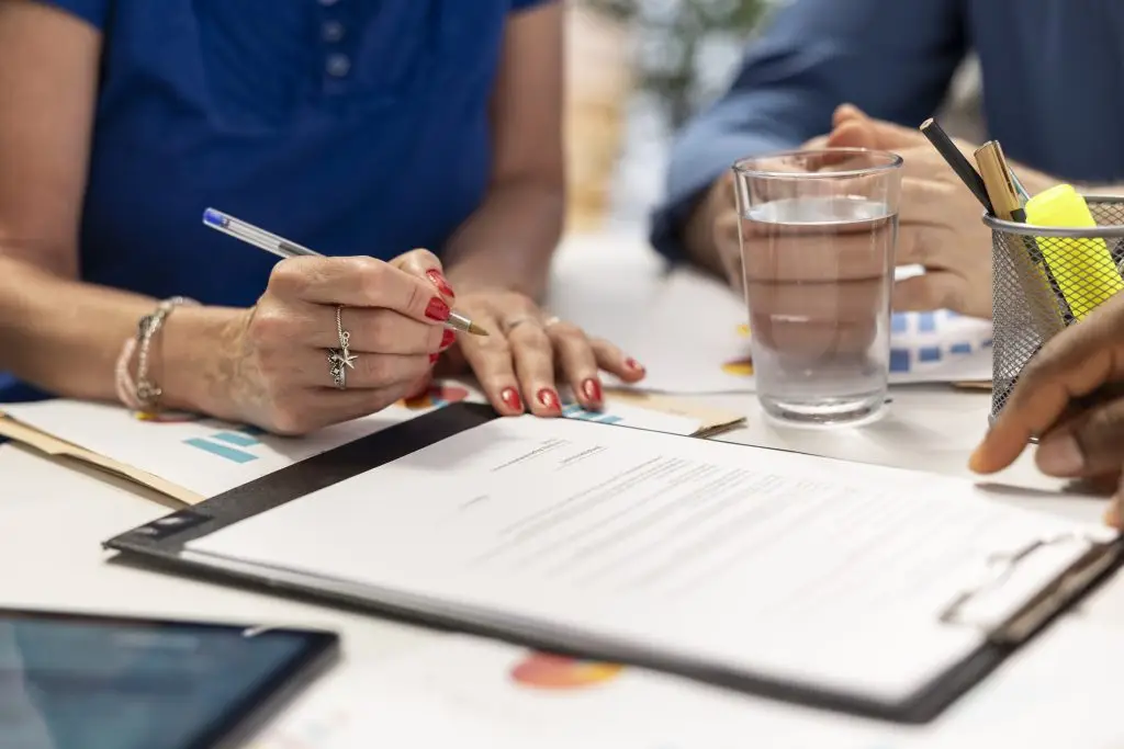 senior woman signing new retirement plan contract meeting